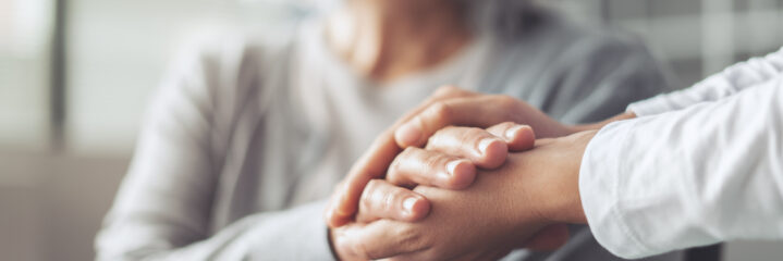 Hands holding old woman's hands